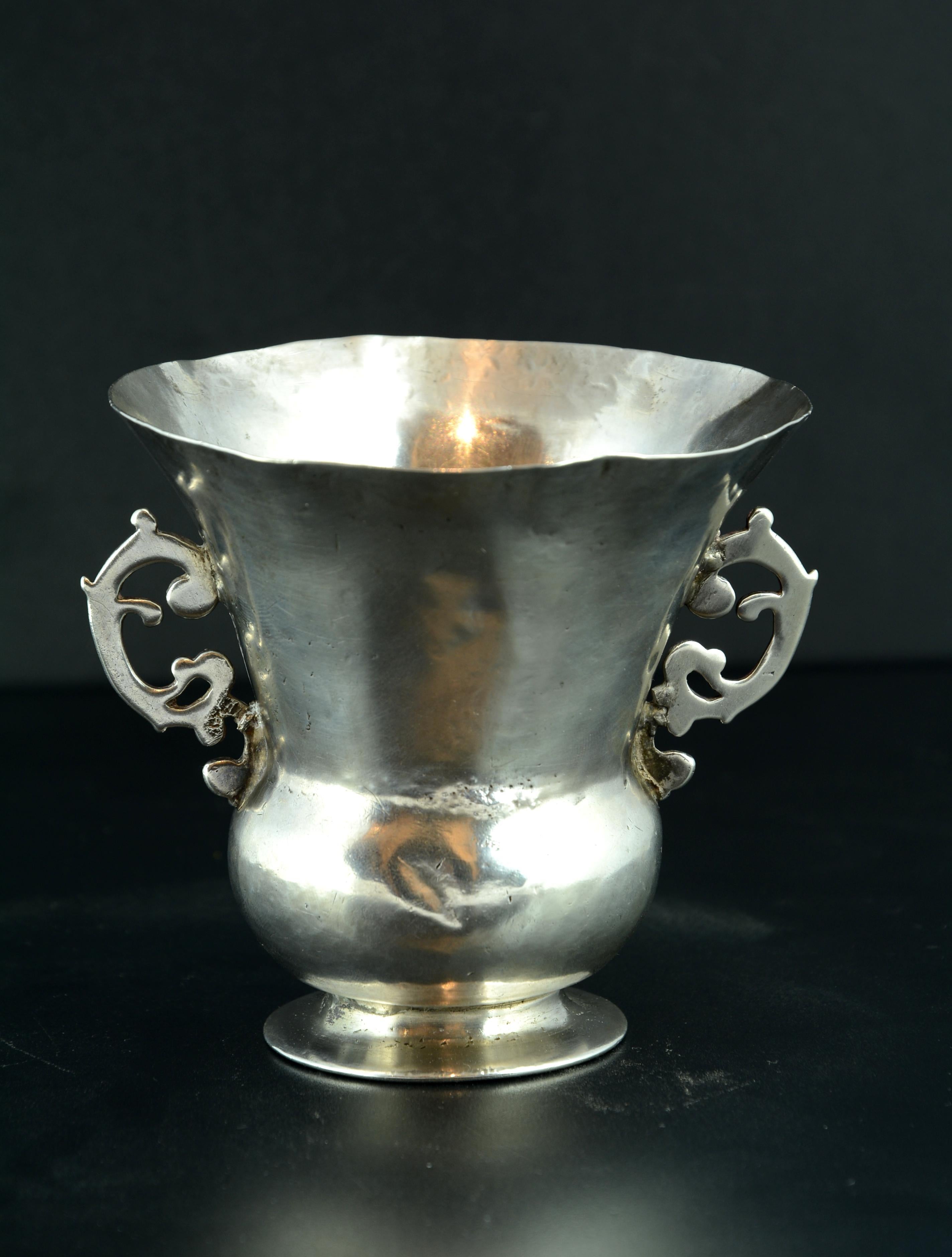 Silver container in its color with circular foot and foot composed of a spherical area and another flared up, which has two handles 