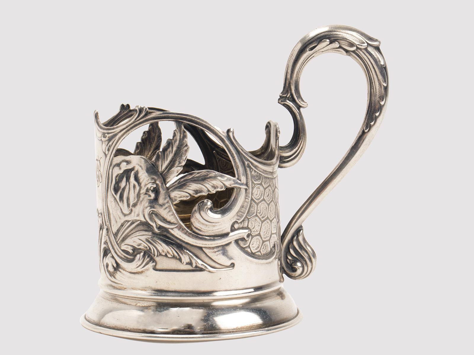 Portabicchieri con manico, realizzato in argento 875/1000 (84 Zolotniki), raffigurante, con tecnica a rilievo, due teste di elefante. Punzone a lettera delta della città di Moscou, Russia, 1900 circa. 