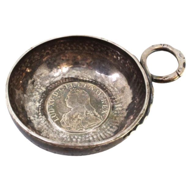 Silver cup with coin reliefs on the bottom for wine tasting