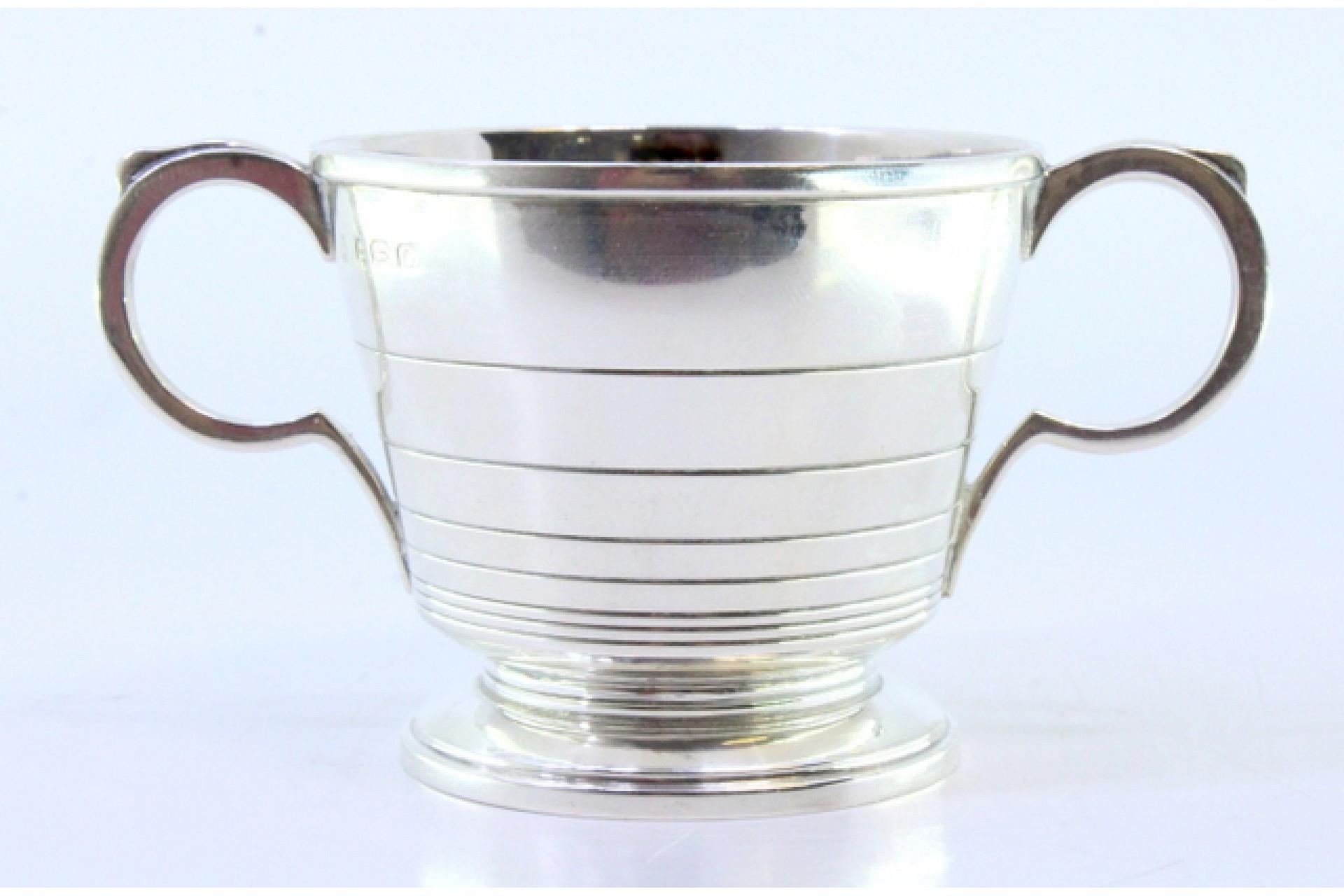 Silver cup with edge friezes, two applied handles and circular base en venta 1
