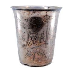 Silver cup with engraved floral motifs surrounding the card