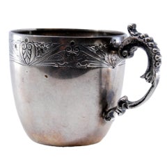 Silver cup with engraving on the bowl and reliefs on the handle