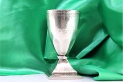 Silver cup with engravings, coat of arms, and square base