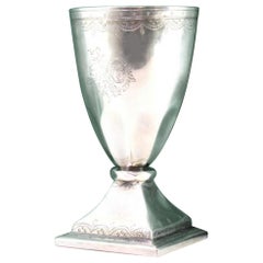 Silver cup with engravings, coat of arms, and square base