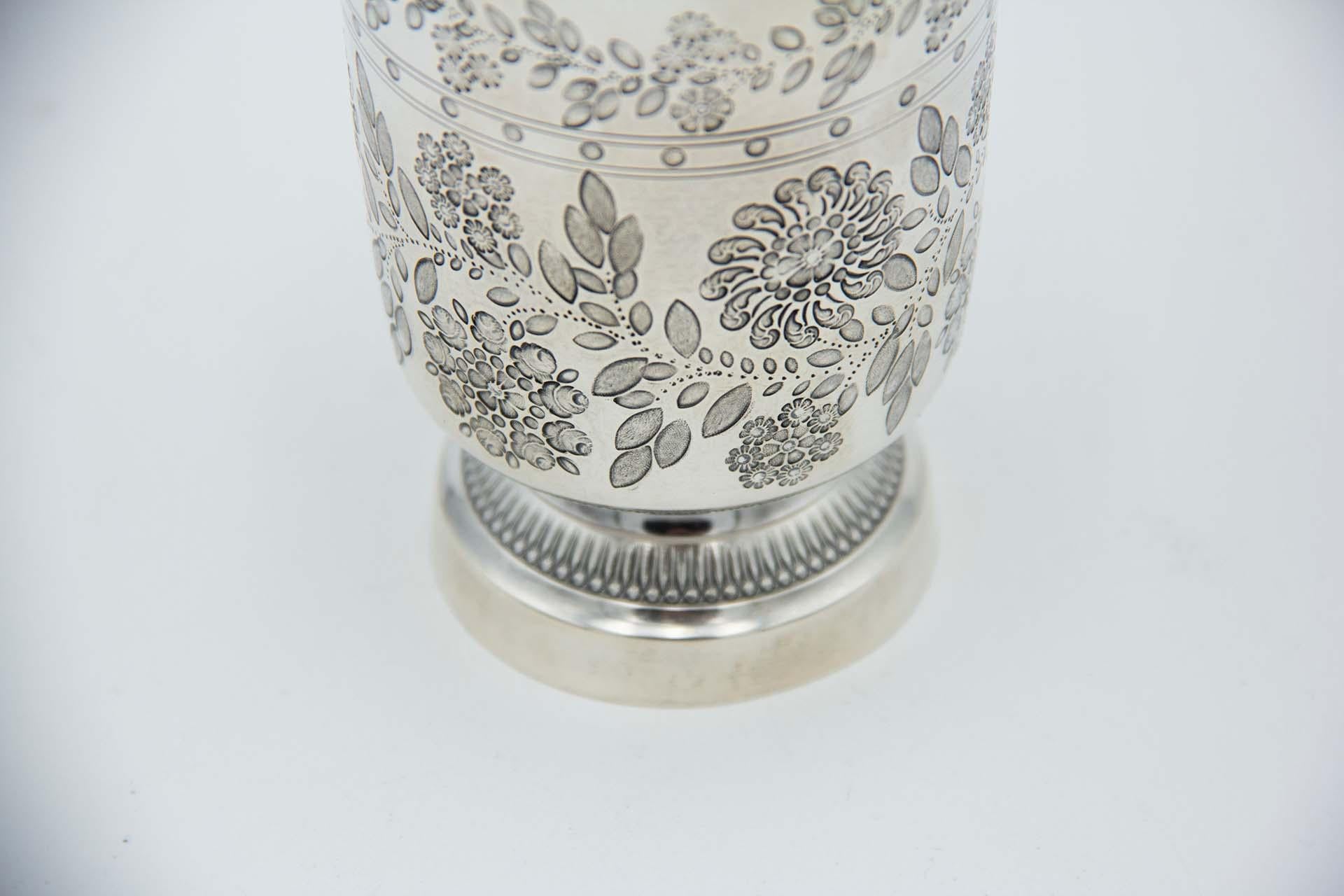 Description: Silver cup with engraved floral motifs and crimped base. Metal: Silver. Origin: French. Brand: Tête Minerve. Weight: 83.42 grams. Dimensions: 8.6cmx11.1cm. Content: 950/1000. Assay Mark: Yes, since 1838. Additional information: Good