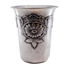 Silver cup with flower and leaf reliefs on the edge