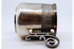 Silver cup with scrolls on the handle and relief on the rim