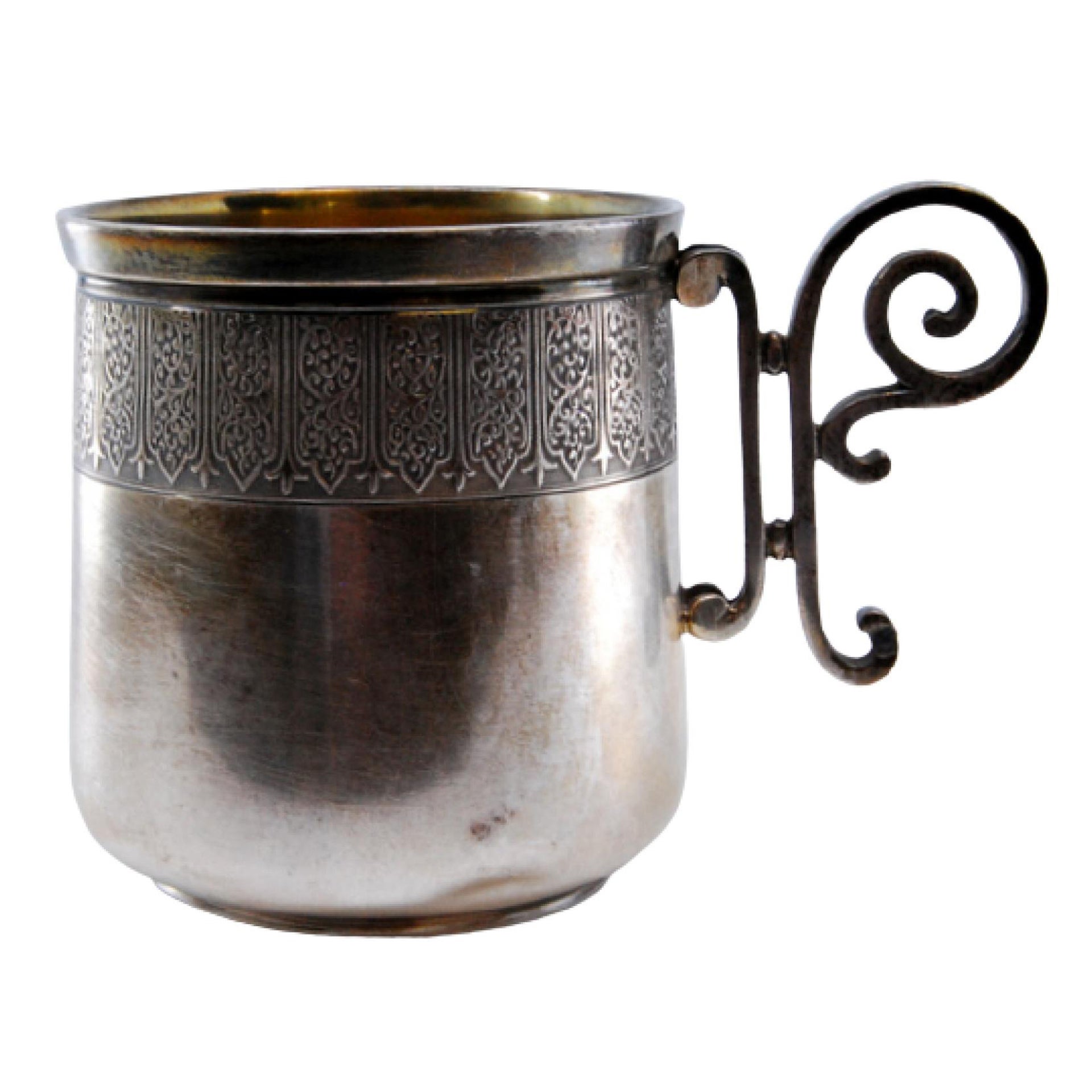 Silver cup with scrolls on the handle and relief on the rim