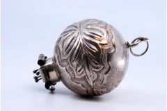 Silver curtain handle shaped like a ball with palms and flower appliqué