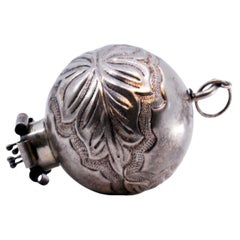 Silver curtain handle shaped like a ball with palms and flower appliqué