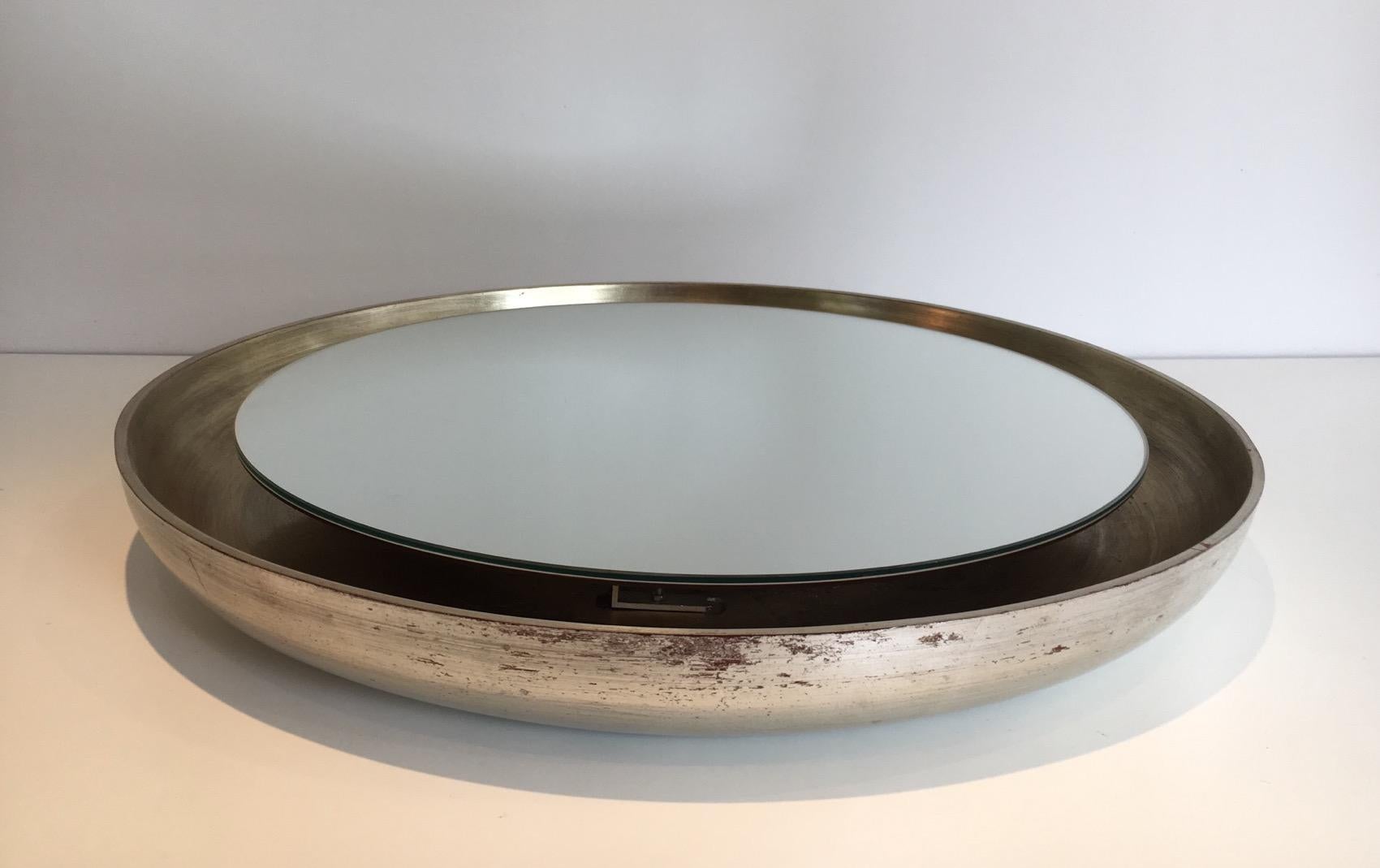This mirror is made of curved wood in a reddish and silver color. This is an unusual model which shape is very nice, circa 1950.