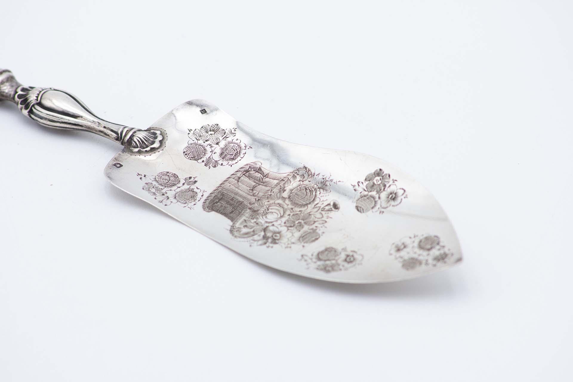 Description: Silver dessert spatula with engraved plant motifs and raised handle. Metal: Silver. Origin: French. Brand: Tête Minerve. Weight: 60.22 grams. Dimensions: 28.5cmx1cm. Content: 950/1000. Assay Mark: Yes, since 1838. Additional
