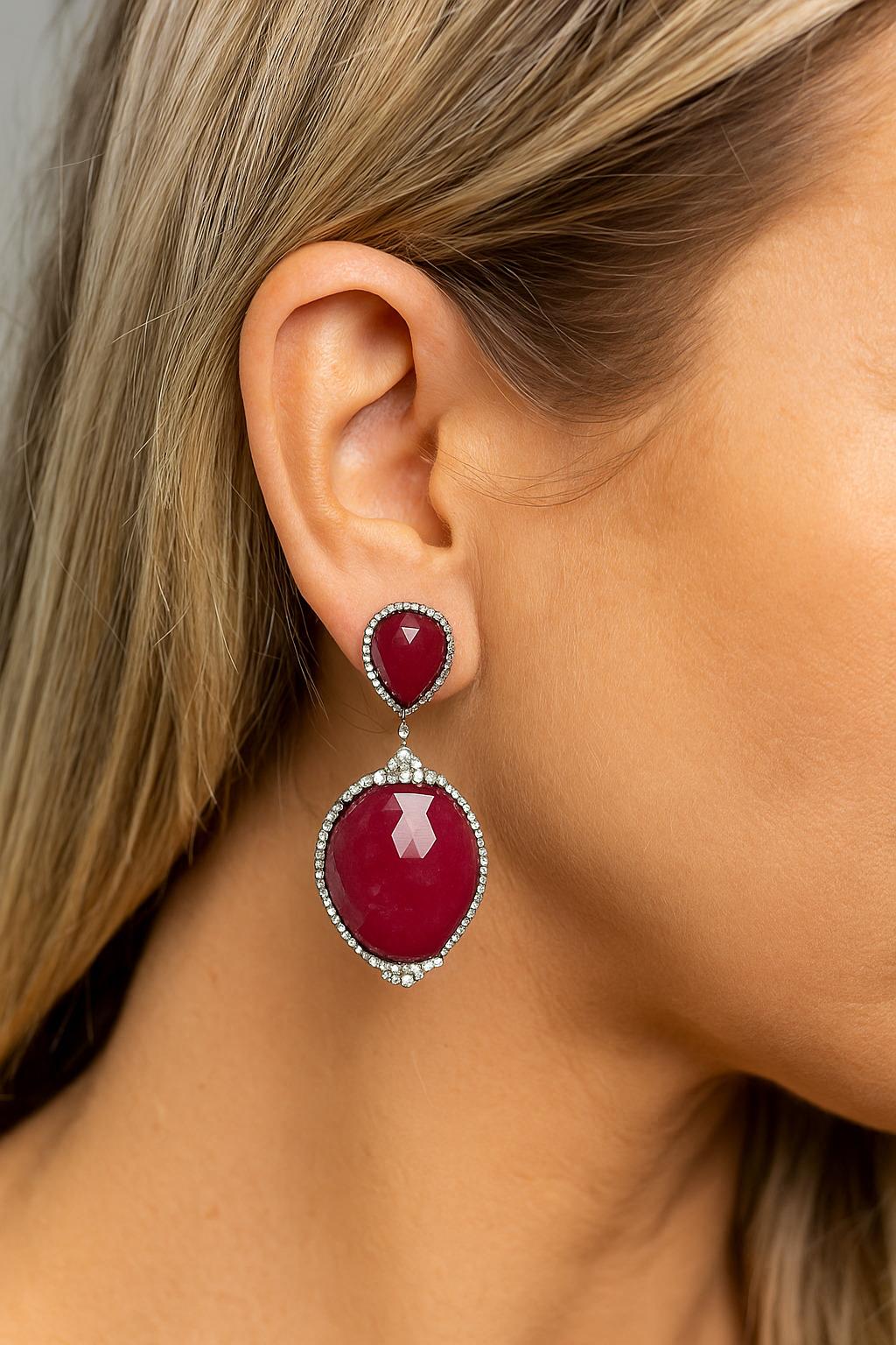 Ces Eleg en argent avec diamants et rubis sont une déclaration audacieuse d'élégance et de sophistication. Conçues dans un style classique en forme de goutte, elles mettent en valeur de magnifiques rubis d'une riche et vibrante couleur vin rouge qui