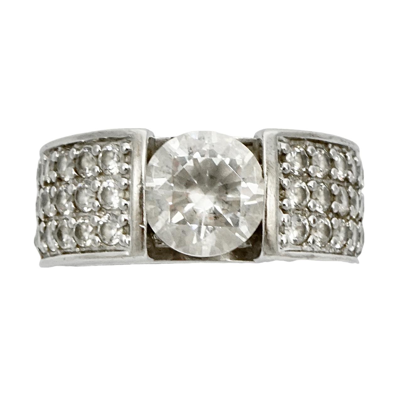 Glamorous silver ring featuring a diamonique cubic zirconia solitaire, and pavé shoulders. Ring size UK K 1/2, US 5 3/8, inside diameter 1.65 cm / .65 inch. The solitaire is diameter .8 mm / .3 inch. There is scratching as expected. 

This is a