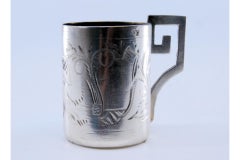 Silver digestive cup with engravings and question-mark-shaped handle