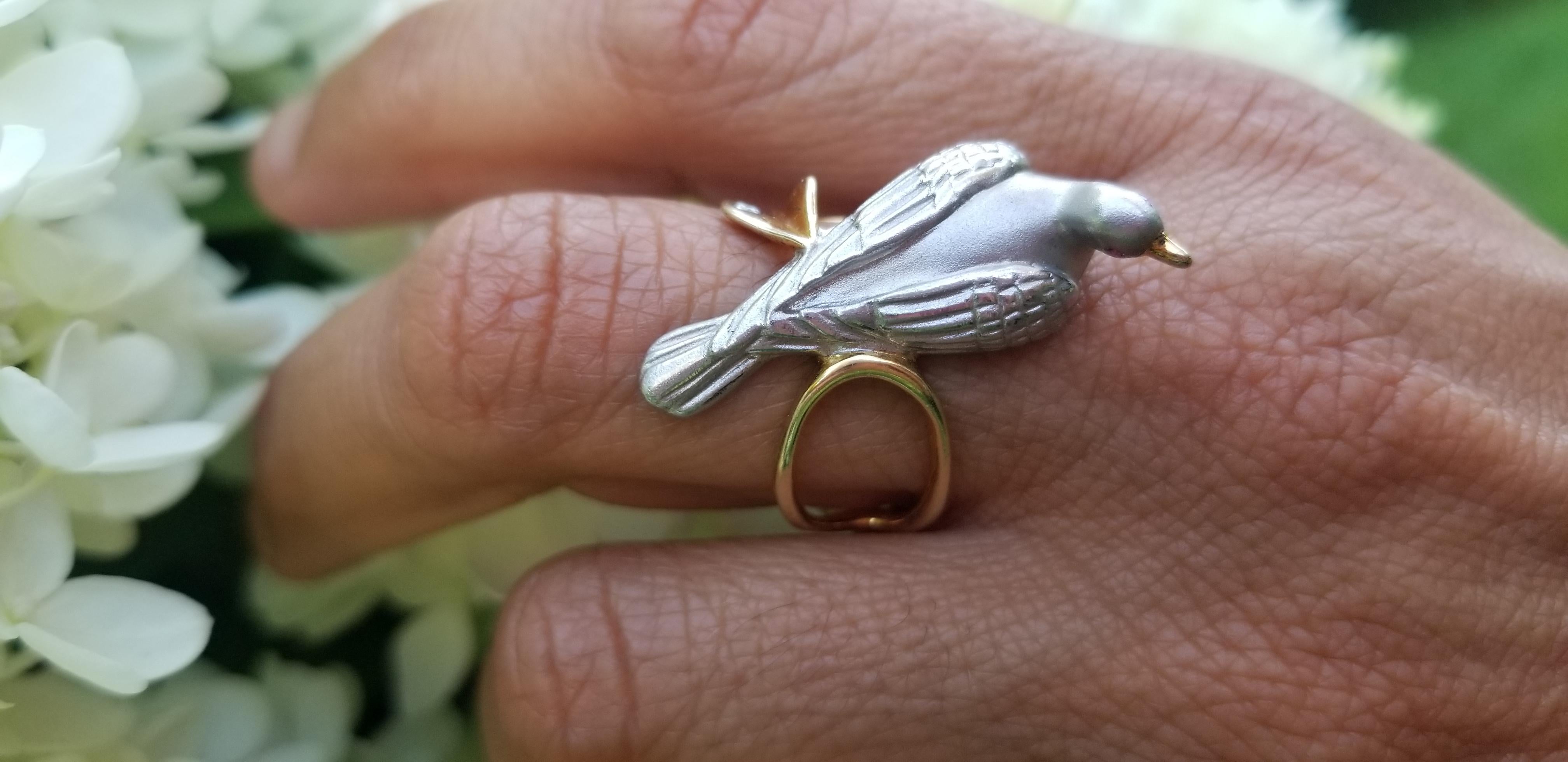 This graceful dove ring was originally hand-carved by New York-based designer Manya of the design team Manya & Roumen. The sinuous gold-plated vine wraps around the finger. A single heart-shaped leaf gently cradled a single white diaming which is