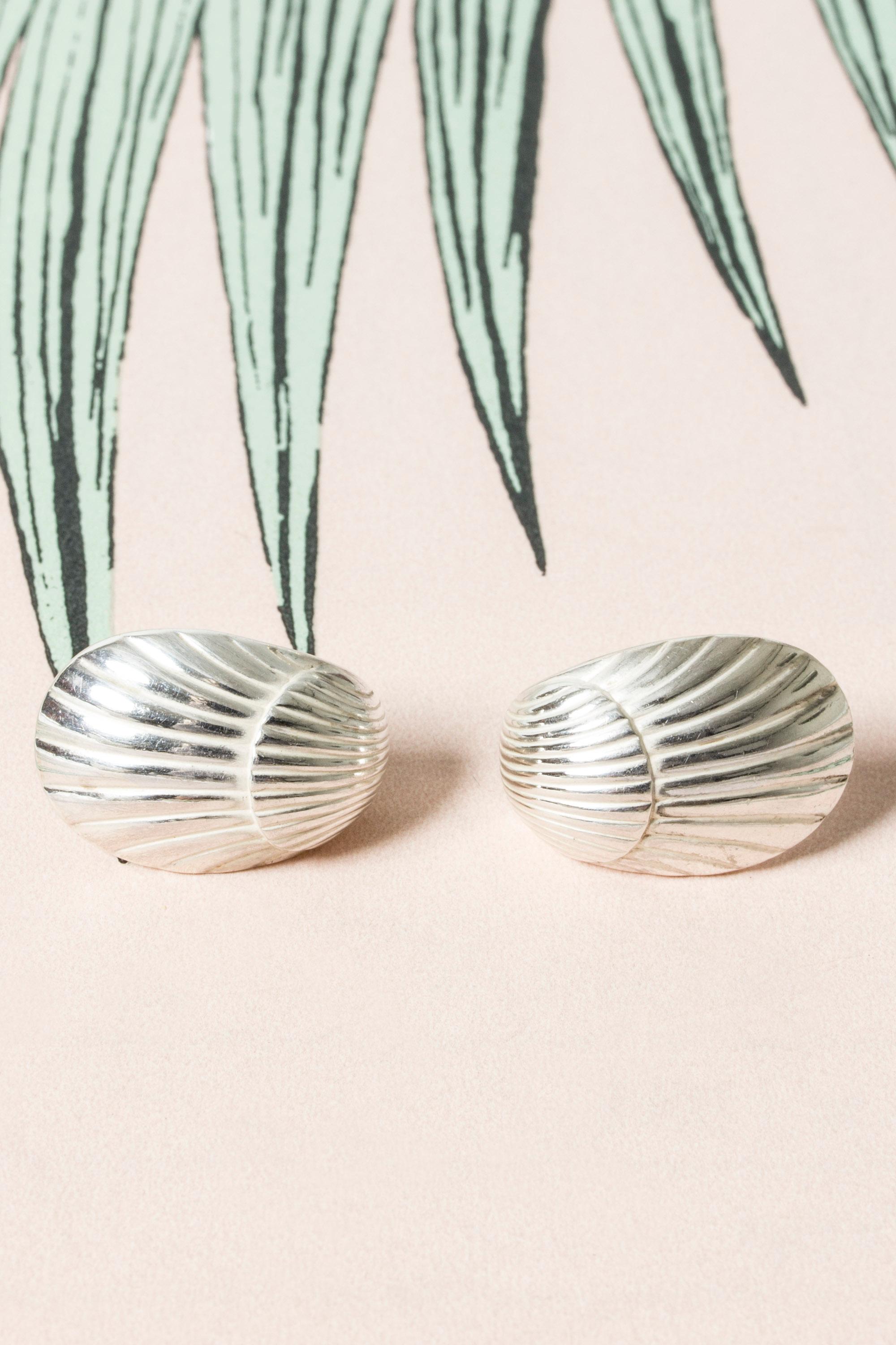 Pair of beautiful silver earrings by Arno Malinowski, in the form of shells. They elegantly curve around the earlobes.