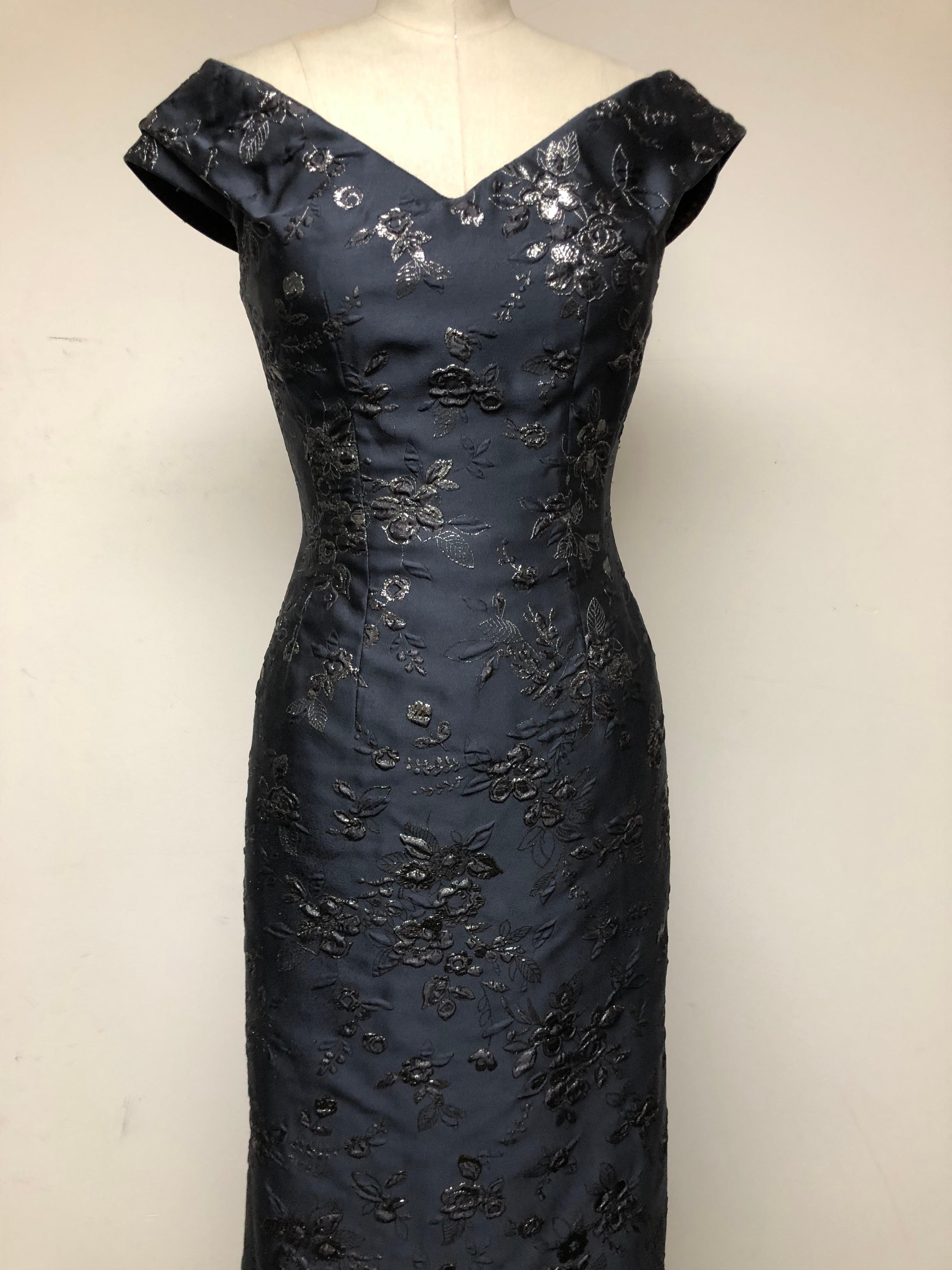 Silver Embroidery on Gunmetal Silk Blend Off the Shoulder Gown. An Internal Bustier is fully lined in matching silk and makes for comfort and a shapely silhouette. A train cascades along the back and leaves a memorable impression. Season-less and