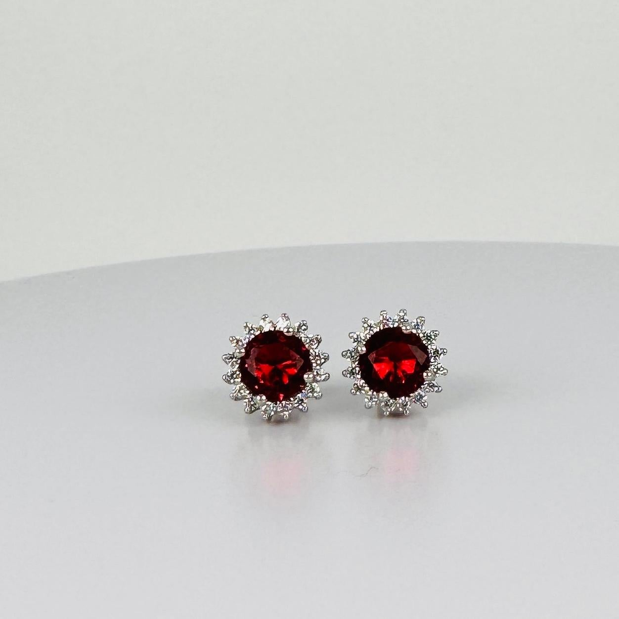 Innamorati di questi splendidi orecchini in argento con un rubino rosso intenso e zaffiri bianchi scintillanti. Perfetta per aggiungere un tocco di eleganza senza tempo a qualsiasi abbigliamento, da quello di tutti i giorni alle occasioni