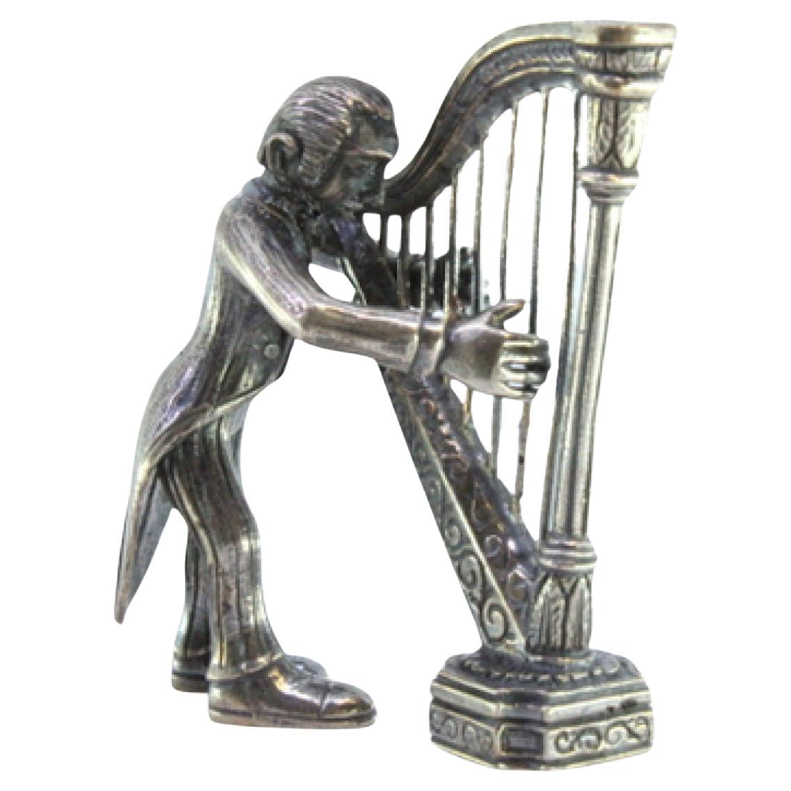 Silver figure of a musician playing the harp For Sale