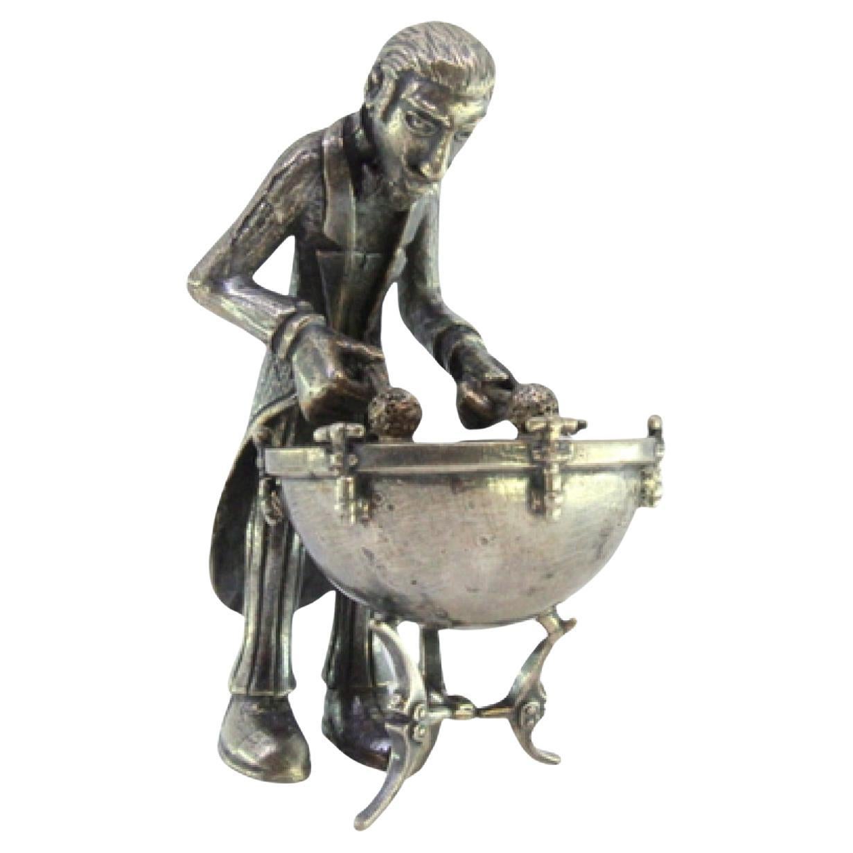 Silver figure of a musician playing the timpani
