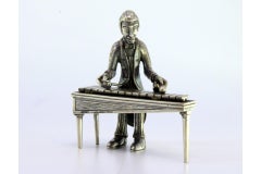 Silver figure of a musician playing the xylophone