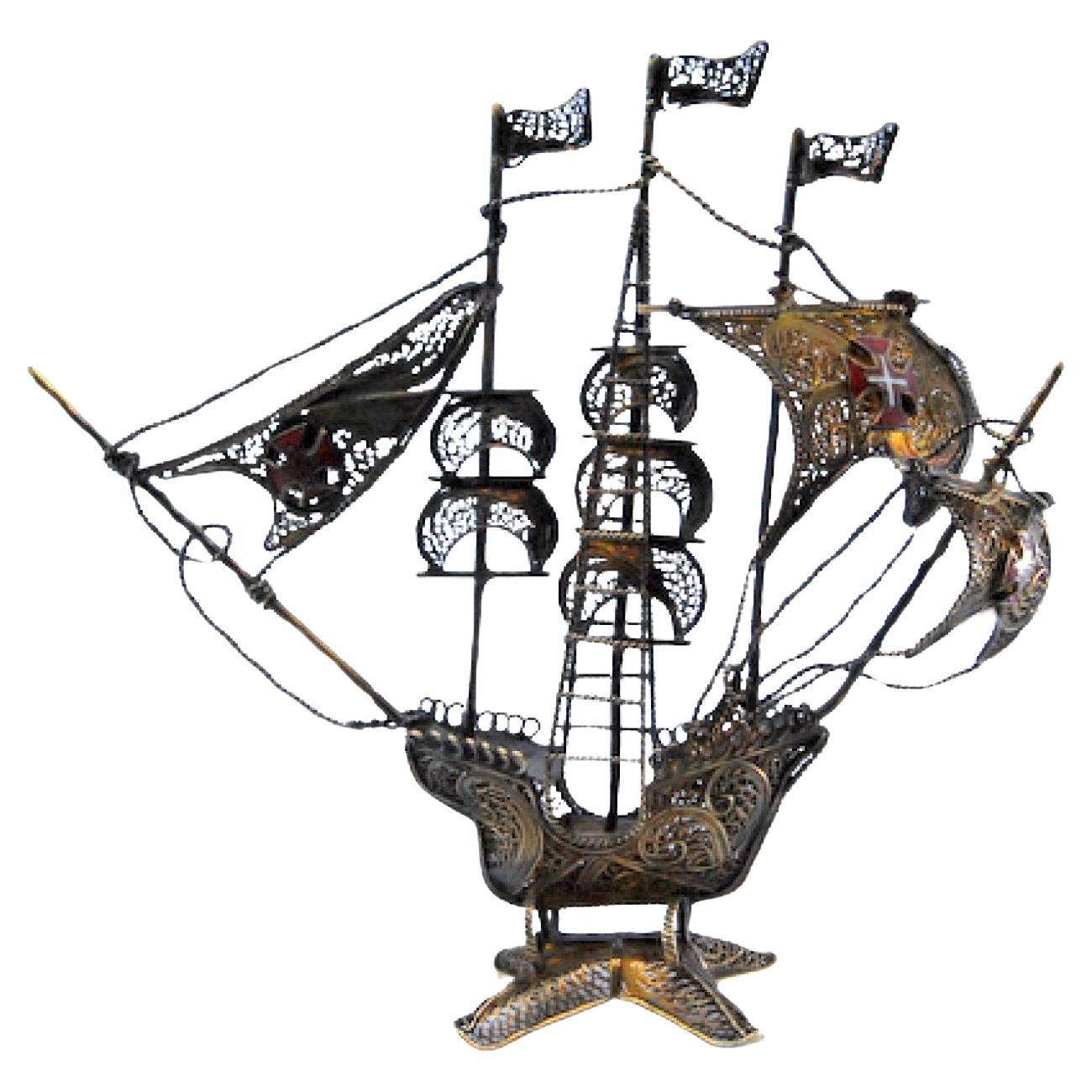 Silver filigree caravel with crosses on sails and scalloped base