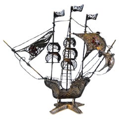 Silver filigree caravel with crosses on sails and scalloped base