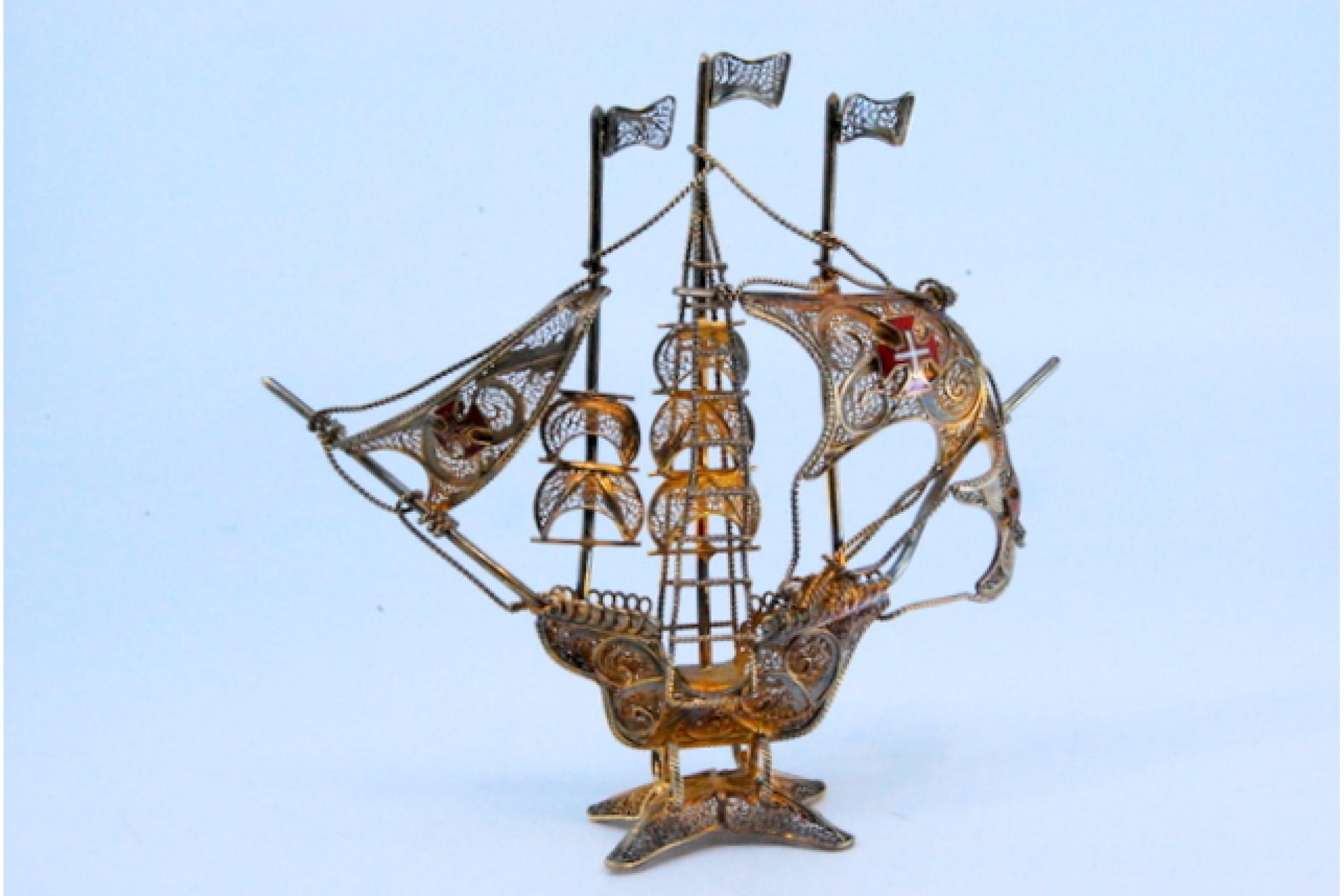 Description: Silver filigree caravel with enameled crosses on the sails and masts, resting on a cut-out base. Metal: Silver. Origin: Portuguese. Mark: Absent. Weight: 56.79 grams. Dimensions: 11x3cm. Content: 925/1000. Assay Mark: Absent. Additional