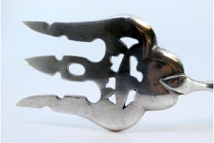 Silberne Fischgabel mit zentraler Fischfigur und erhabenem Griff mit Fries