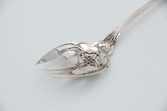 Silver fish fork with cutouts and reliefs