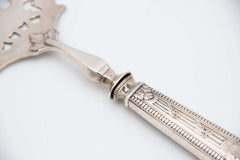 Silver fish fork with reliefs and detailed engravings on handle