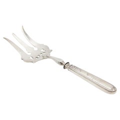 Silver fish fork with reliefs and detailed engravings on handle