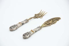 Silver fish knife and fork with gold trim and raised handles