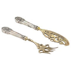Silver fish knife and fork with gold trim and raised handles
