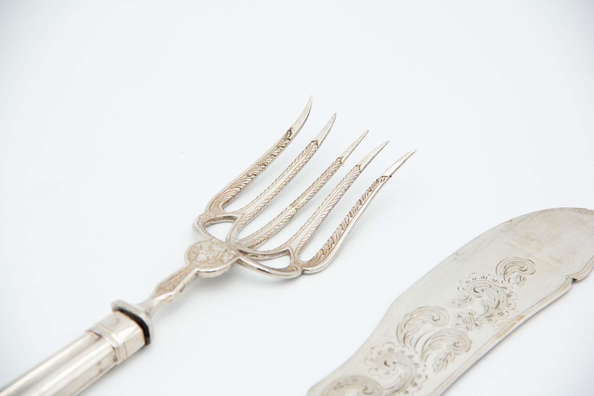 Description: Silver fish knife and fork with reliefs, engravings and fluted handles. Metal: Silver. Origin: Portuguese. Brand: Lisboa Coroa. Weight: 286.65 grams. Dimensions: Fork 23.5cmx1.5cm  . Content: 833/1000. Assay Mark: Yes, from the 15th