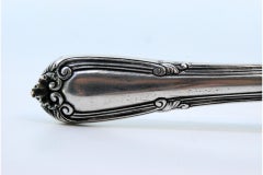 Silver fish knife with a fish figure in the center and a beaded handle