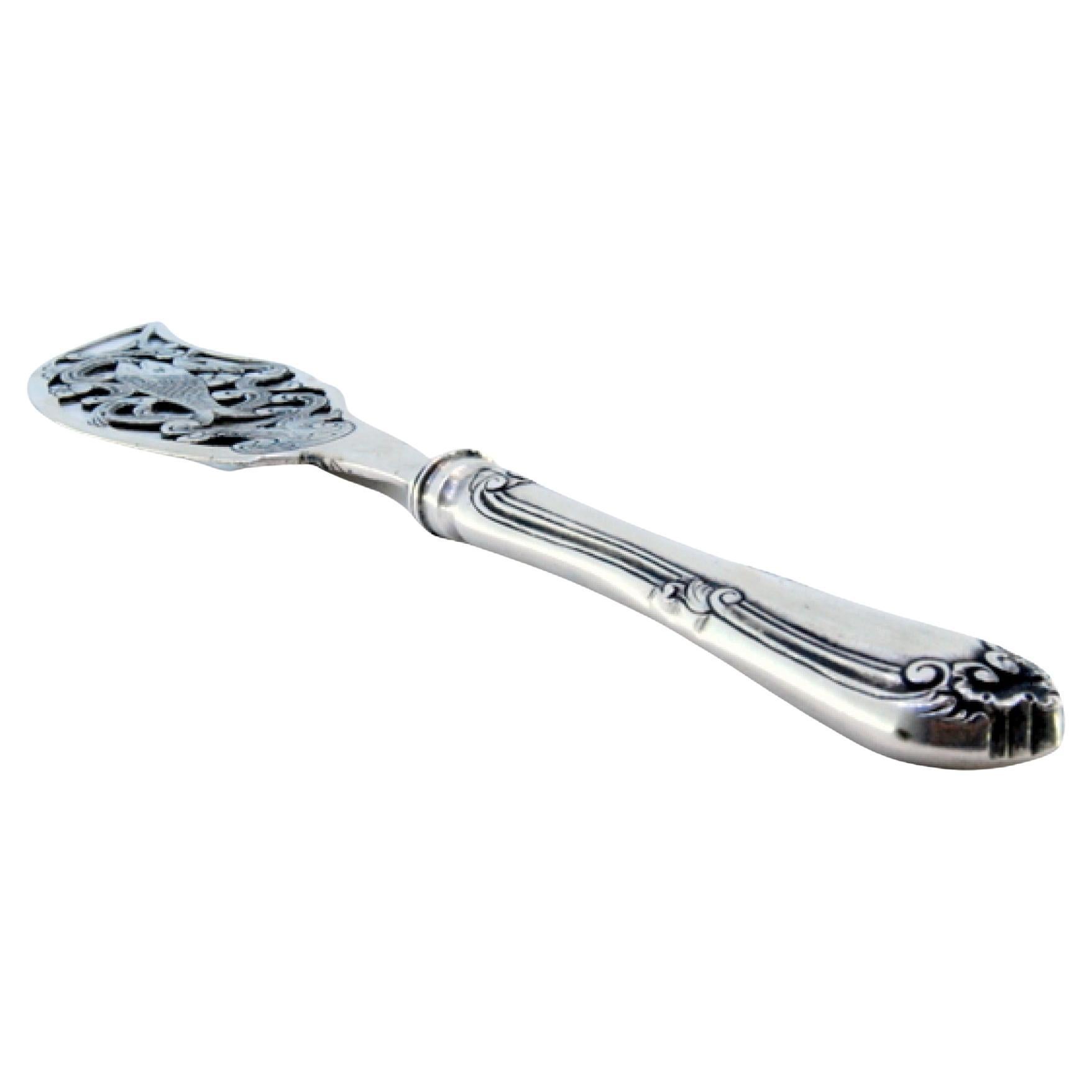Silver fish knife with a fish figure in the center and a beaded handle