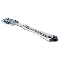 Silver fish knife with a fish figure in the center and a beaded handle