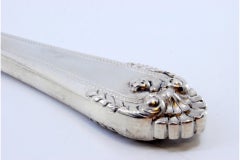 Silver fish serving fork w/ 4 engraved prongs, friezes & a shell on the handle