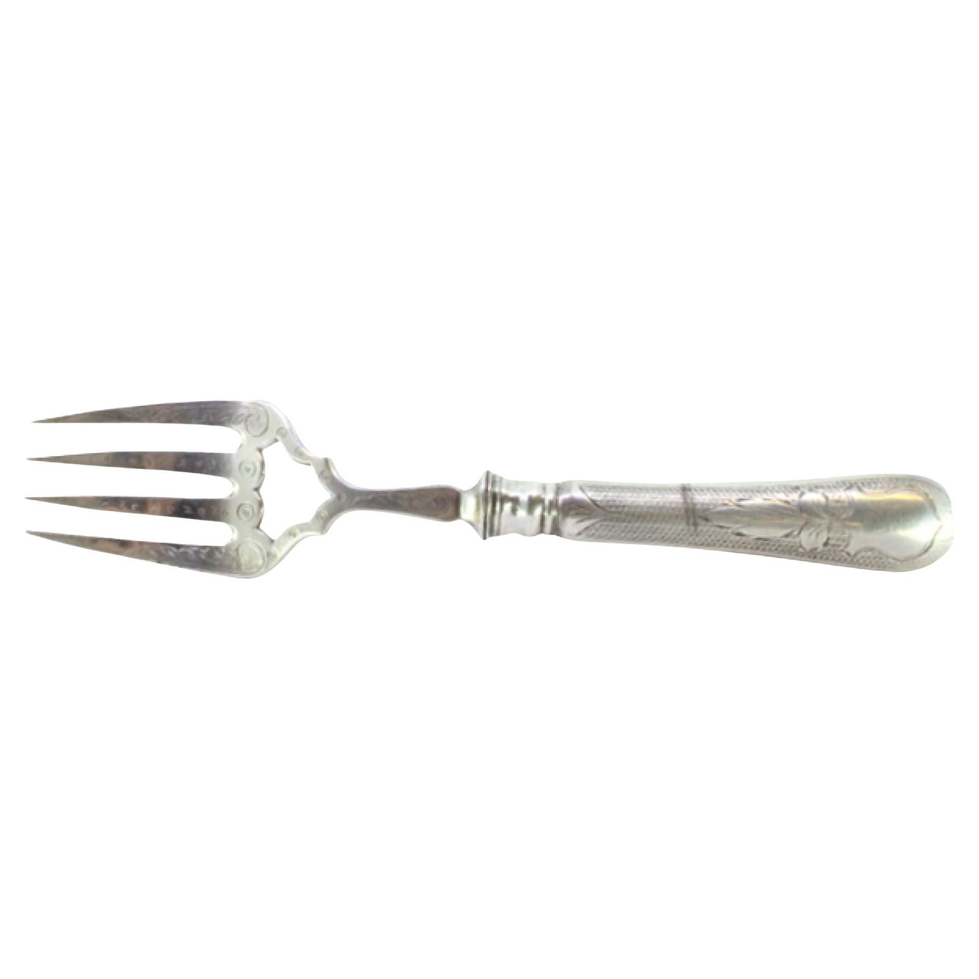 Silver fish serving fork w/ engravings surrounding a monogram card on the handle
