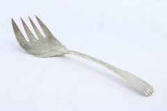 Silver fish serving fork with a revealed handle and flower and four tines