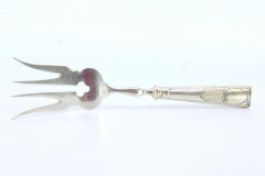 Silver fish serving fork with engraving on the handle and a monogram card