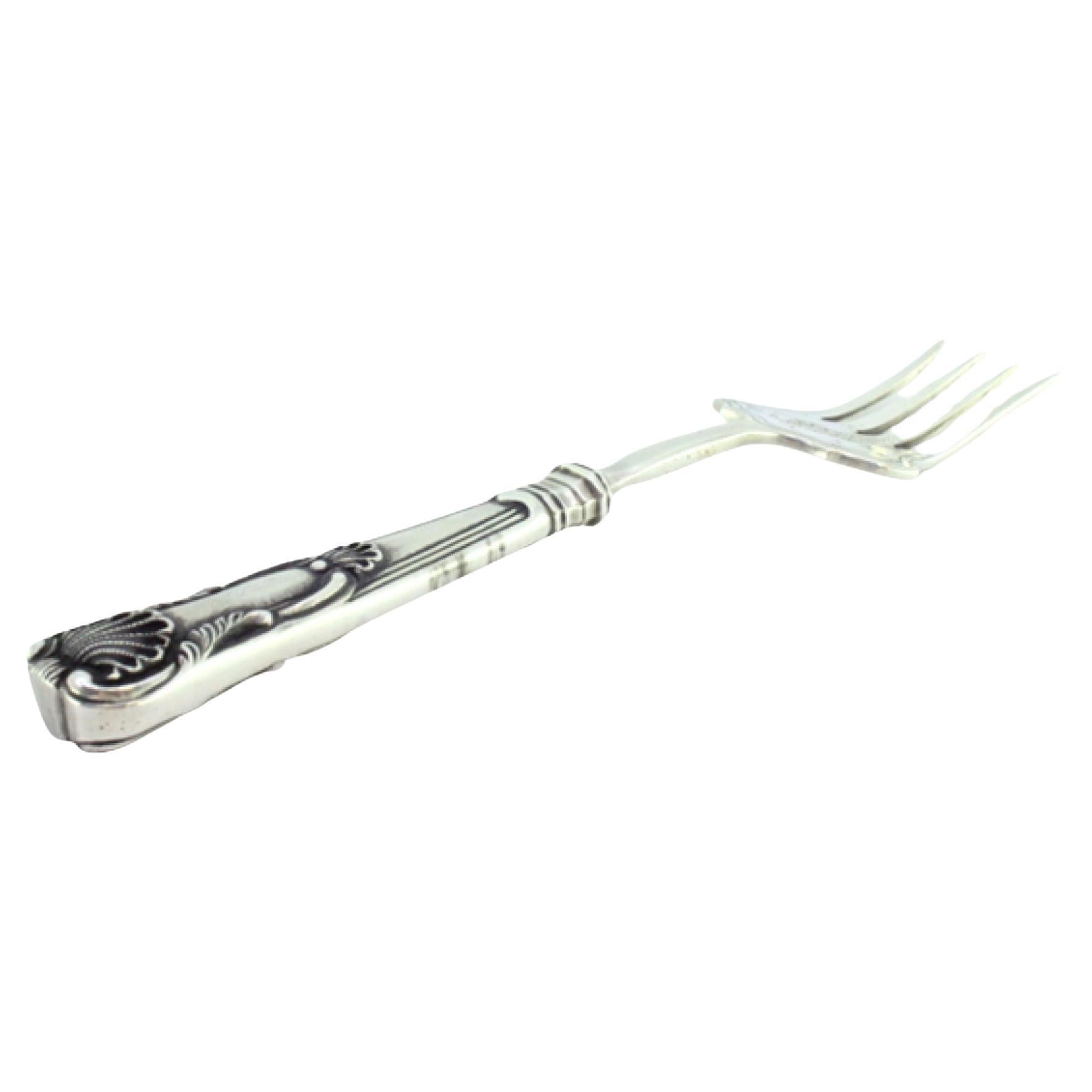 Silver fish serving fork with engravings and reliefs on the handle