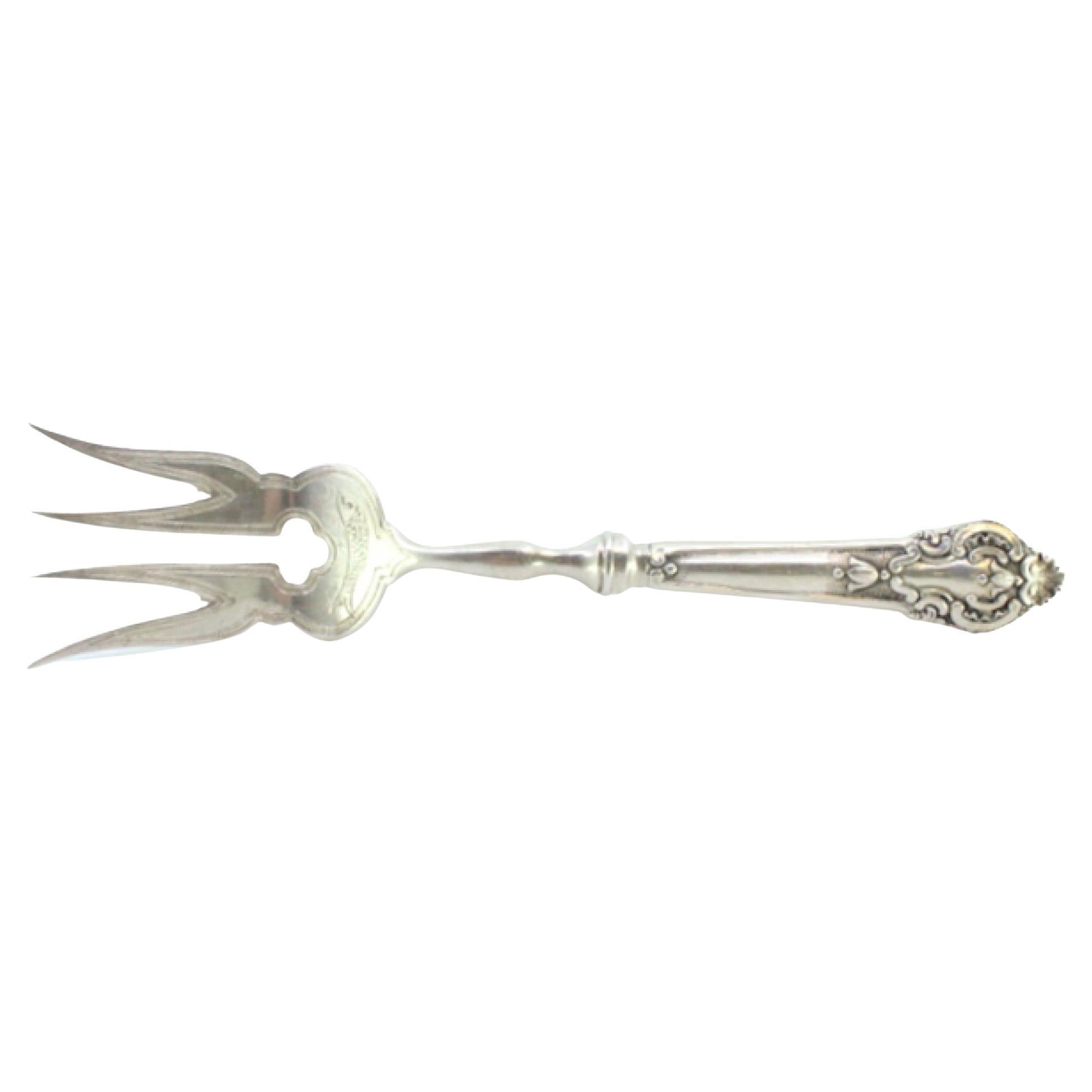 Silver fish serving fork with engravings and reliefs on the handle