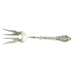 Silver fish serving fork with engravings and reliefs on the handle