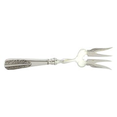 Silver fish serving fork with floral motifs in relief on the handle