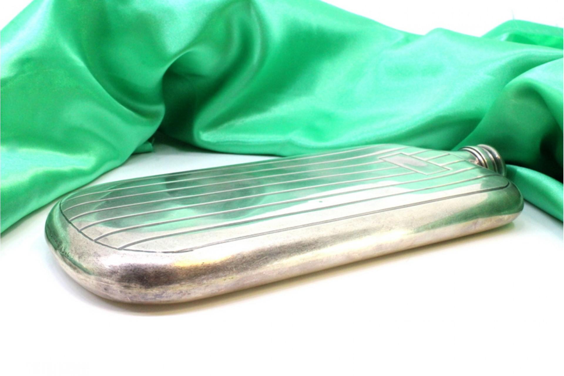 Description: Silver hip flask with bands at the top and a monogrammed card in the center, with a screw cap. Metal: Silver. Origin: European. Brand: Unknown. Weight: 259.33 grams. Dimensions: 10.5cm x 22.5cm. Content: 925/1000. Assay Mark: Yes.