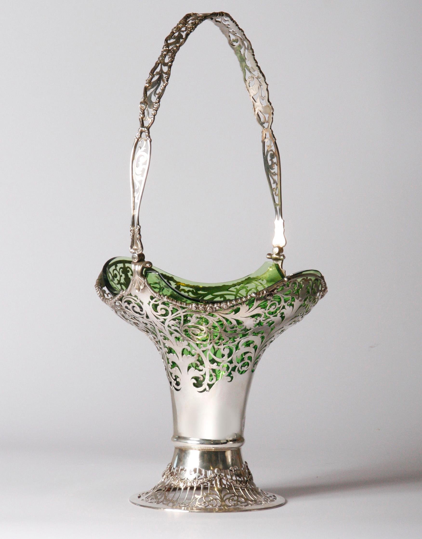 Schöner und großer silberner Blumenkorb.
Die Vase wurde von Mappin & Webb London hergestellt. Das Silber ist reichhaltig bearbeitet und ajour gesägt. Das Glasinnere ist original und aus grünem, handgefertigtem Glas hergestellt. Diese ist noch