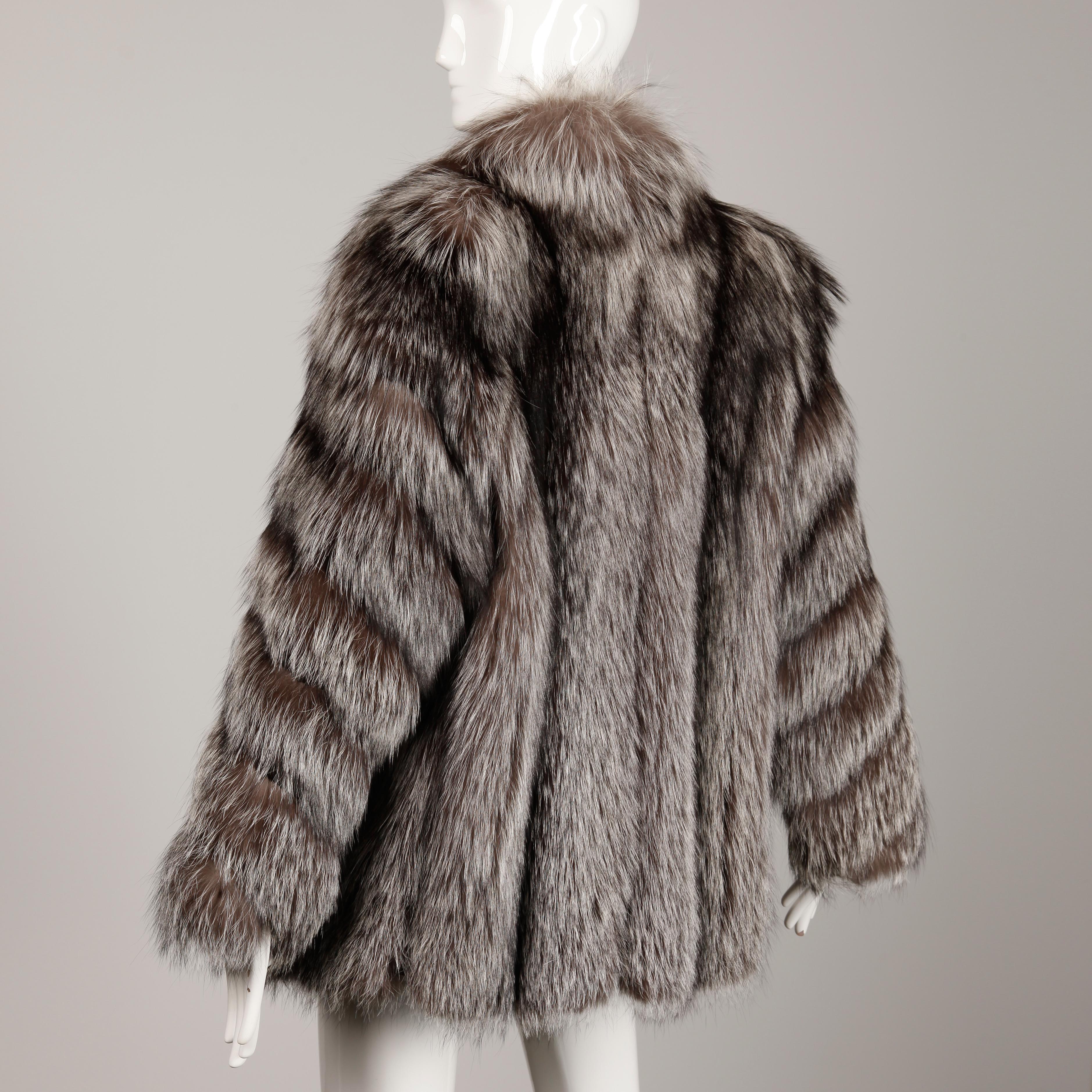 Absolutely stunning vintage chubby silver fox fur coat or jacket by Saga Furs. This coat is in beautiful condition with no shedding or drying to the pelts. It was always kept in cold storage and comes from a celebrity estate. It features velvet